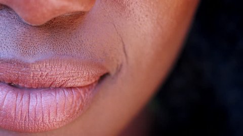 One side of the mouth of a smiling black woman, detail