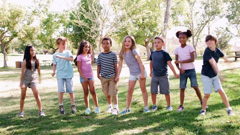 Group Of Children With Friends In Park Dancing And Flossing