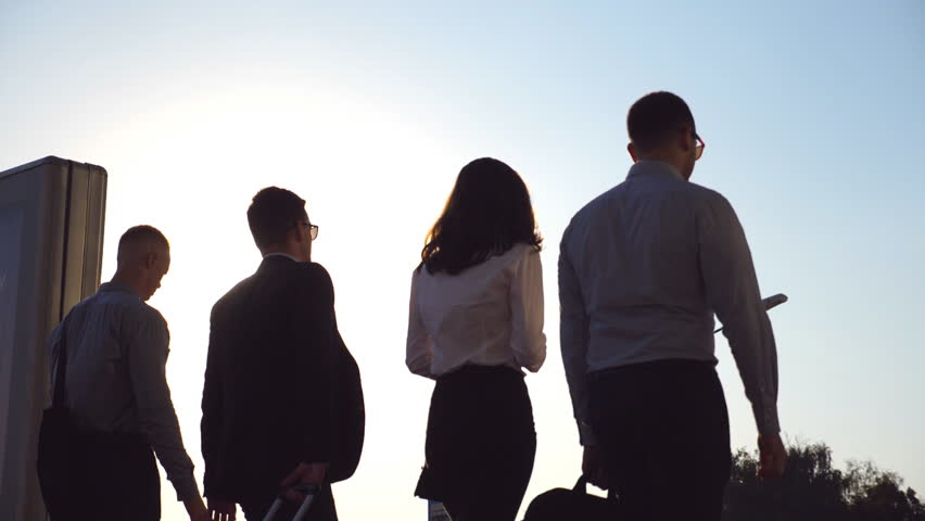 Group of young businessmen walking in city street at sunset time. Colleagues being on his way to home after hard day work. Sun flare at background. Success concept. Slow motion Close up Rear back view Royalty-Free Stock Footage #1017612172