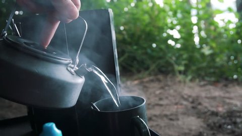 Hot Water Getting Poured Into A Cup In The Wilderness
