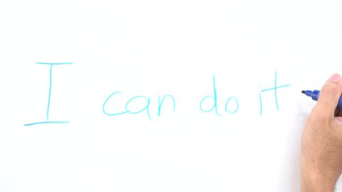 Student hand writing on whiteboard word "i can do it" in school classroom