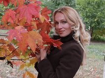 Beautiful girl laughs under an autumn tree