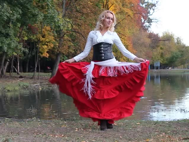 Beautiful woman waving a skirt on the lake shore