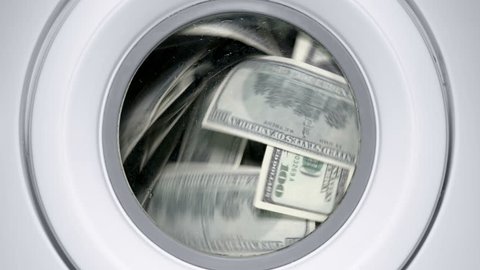 in a drum of a washing machine, money and dollars are spinning and laundered, close-up