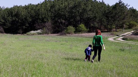 mother and little boy go on the field