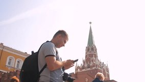 Travel and technology. Happy tourist man looks the navigator smartphone taking lifestyle selfie with backpack. slow motion video. on Red Square in Moscow, Russia. tourist journey travel man in Russia