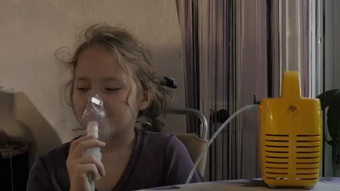 sick girl is inhaled with nebulizer at home. slow motion