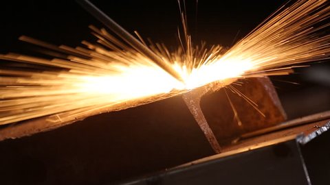Welder In Workshop - stock-photo-welder-in-workshop-manufacturing-metal-construction-by-cutting-to-shape-using-huge-orange-sparks