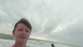young woman takes herself to the camera on the beach