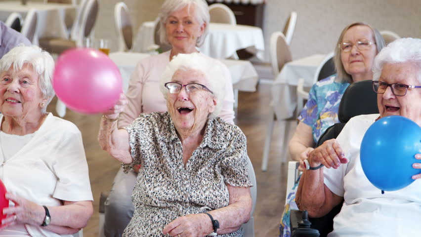 Group Of Seniors Enjoying Fitness Class In Retirement Home Royalty-Free Stock Footage #1017650572