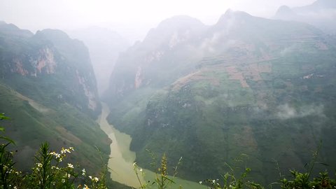 Time lapse stunning view of the Nho Que river surrounded by mountains from the Ma Pi Leng pass in northern Vietnam during the foggy and misty morning.