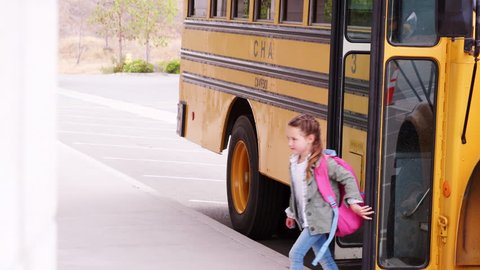 Elementary schoolchildren getting off school bus in morning
