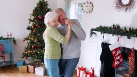 Romantic Senior Couple Dancing Together At Home With Christmas Tree In Background - Powered by Shutterstock - Get 15% off with code: PIKWIZARD15