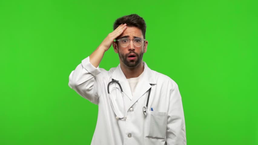 Young doctor man on green chroma worried and overwhelmed, forgetful, realize something, expression of shock at having made a mistake Royalty-Free Stock Footage #1017671623