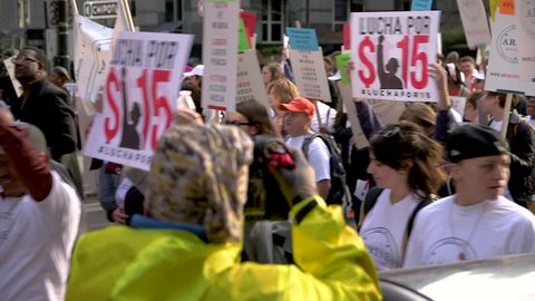 Protesters march and chant at a rally for minimum wage rights in Chicago, IL.