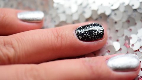 Woman hand with fashion famous manicure black silver glitter sequins paillette spangle shine