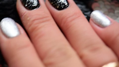 Woman hand with fashion famous manicure black silver glitter sequins paillette spangle shine close up