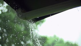 Water drips from a rain gutter in slow motion that is overflowing during a downpour.  This is a great clip to show unusual weather or for home improvement shows.