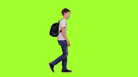 Schoolboy with backpack walking on green chroma key background, Side view, 4k pre-keyed footage