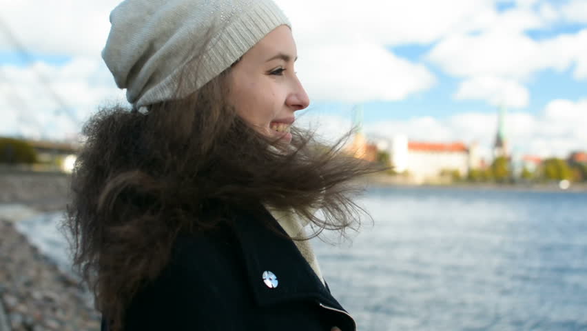Beautiful young lady is looking far into the distance with Old City panorama on the background