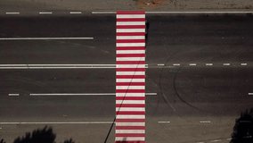 trucks are driving on the highway with a pedestrian crossing in red and white colours. Aerial view