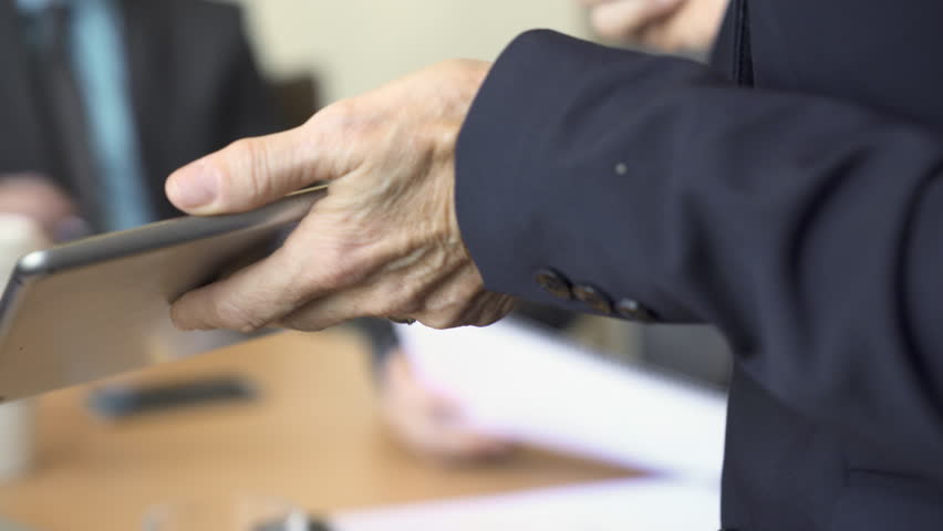 Businesswoman holding tablet computer and pen while giving presentation to colleagues in board room | Shutterstock HD Video #1017682756