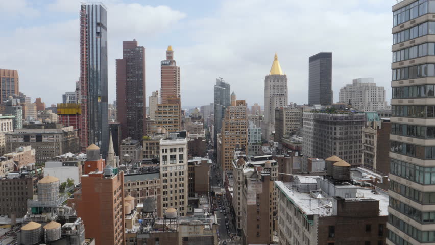 A wide high angle view buildings near Madison Square Park in Manhattan on a early Autumn day. The New York Life Tower is seen in the distance.  	