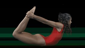 amazing female yoga instructor moving between poses in red costume with video distorted background