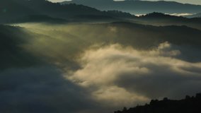 AERIAL 4K: Flight over mountain road and the greenhouse with fog clouds sun rise on mountain in fog in area of Dalat, Vietnam
