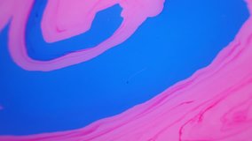Stains of blue and pink ink on the water. Abstract background footage.
