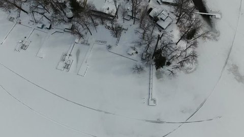 Aerial view of shoreline cottage winter landscape by a snow covered lake