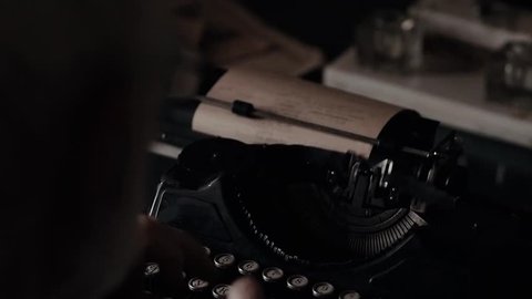 The hands of an old man are typing on an old typewriter, a writer's antique instrument, a poet or a writer composing a printed work, an old furnishings, beginning of the 20th century, handwriting