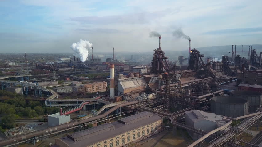 Extremely close drone circular flight of blast furnaces of metallurgical plant;heavy industry of high-strength rolling metal;one of the largest steel plant in the world; air emissions of harmful gases Royalty-Free Stock Footage #1017723424