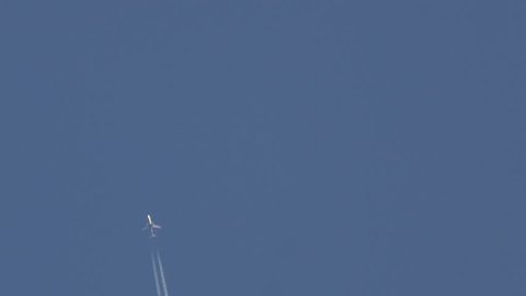 Jet Airplane Flying In Blue Sky With White Contrails
