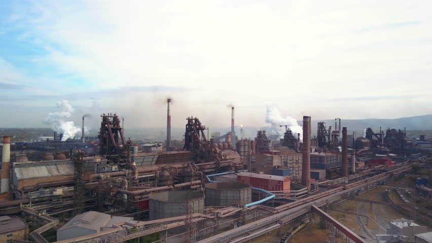 Aerial panorama of industrial buildings, lot of workplaces and developed infrastructure of plant, in contrast detrimental nature impact, atmosphere emissions, air pollution; unhealthy lifestyle;  Royalty-Free Stock Footage #1017726553