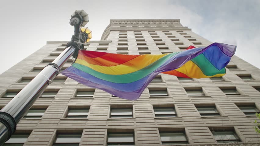 LGBTQ rainbow flag flapping in slow motion on a pole in San Francisco