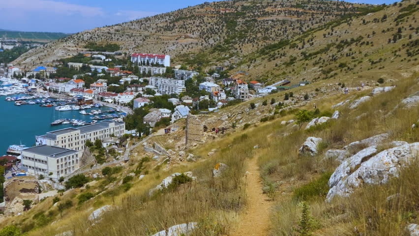 The city is surrounded by a mountain landscape. The general plan of the bay, taken from a high point. A small wind shakes the deciduous trees against the background of the bay.