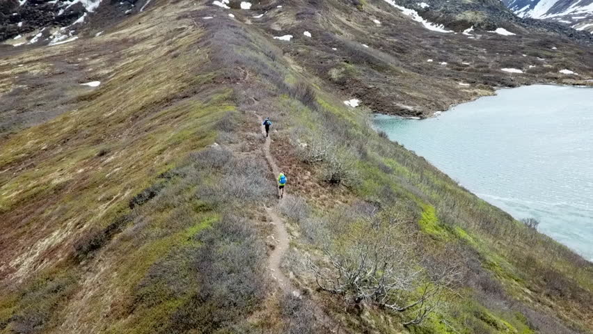 Aerial View Behind Two Hikers on a Trail Ridge