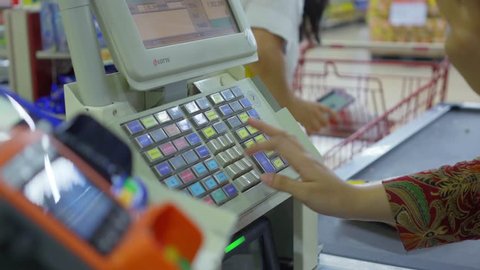 JAKARTA, Indonesia - October 10, 2018: Cashier hand registering orders on the cash register machine in the supermarket shop. Shot in 4k resolution