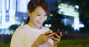 woman play mobile game happily at night