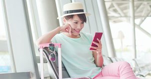 woman sit and use phone happily in the station