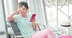 woman sit and use phone happily in the station