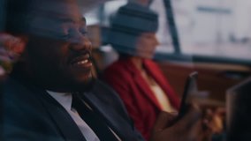 Handsome Businessman and Beautiful Businesswoman Riding on the Backseat of a Car in the Evening. Man Makes a Phone Call, Woman Works on a Laptop. Camera Shot made from Outside the Car. - Powered by Shutterstock - Get 15% off with code: PIKWIZARD15