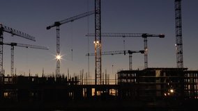 Mechanical construction cranes working sunrise above skyline. FullHD video clip
