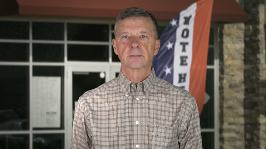 I Voted Today sticker on the shirt of a casually dressed senior caucasian man saying I Voted in midterm elections in the USA