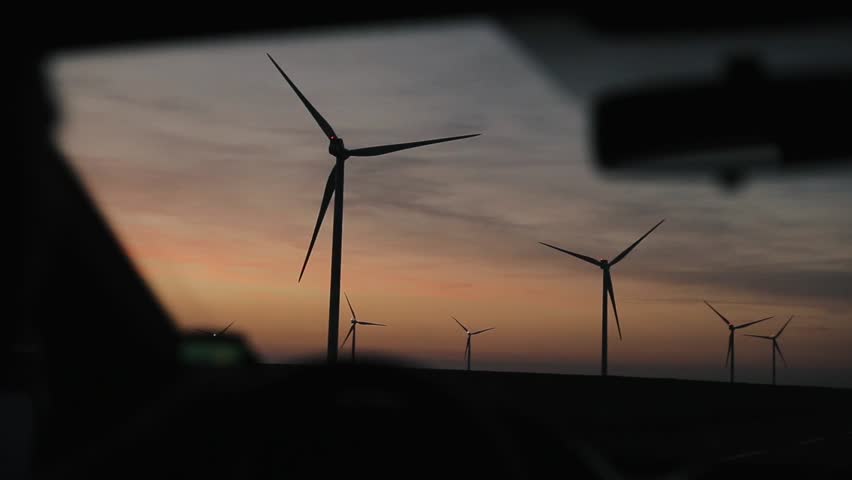 Driving past windmills with beautiful sunset sky in the background Royalty-Free Stock Footage #1017769345