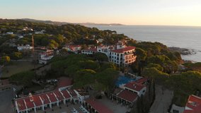 Aerial video view of a mountain green bay filled with blue water on a bright sunny day, Catalonia, Spain, Sant Pol, Sagaro, 4K. 