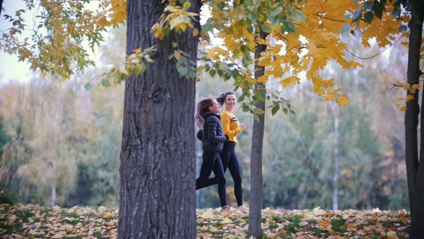 Gymnastic girls running in the autumn park