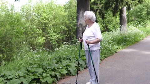 grandmother walks with Nordic walking sticks old grey