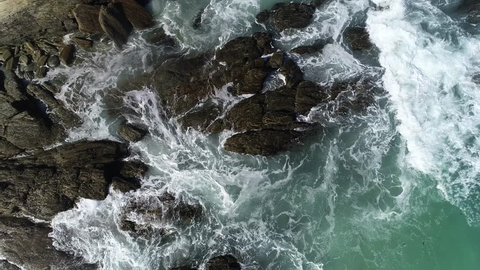 Aerial view of ocean waves and fantastic Rocky coast at New Zealand. Danger sea wave crashing on rock coast with spray and foam before storm in Brighton Beach, New Zealand.